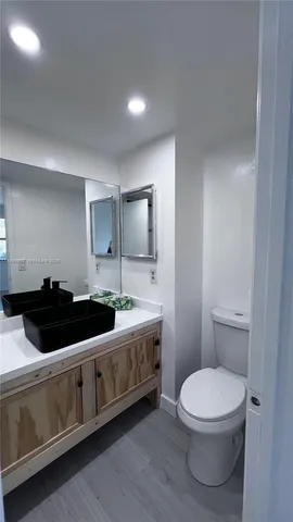 a bathroom with a toilet a sink and mirror