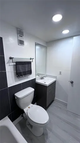 a bathroom with a toilet a sink and mirror