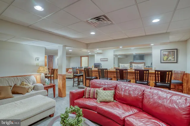 a dining hall with stainless steel appliances granite countertop a sink a stove a dining table and chairs with wooden floor