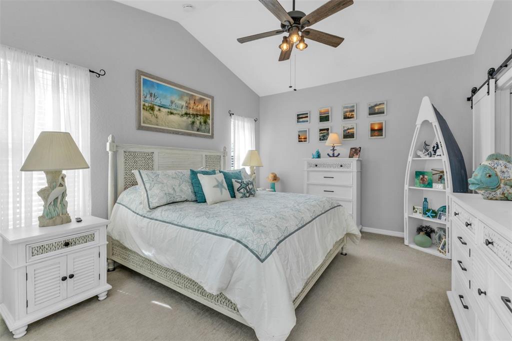 24439 Buckingham Way Punta Gorda, FL 33980 - Photo 13 of 42 a spacious bedroom with a bed and a chandelier