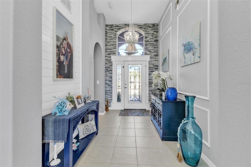 24439 Buckingham Way Punta Gorda, FL 33980 - Photo 4 of 42 a hallway with painting on the wall and a potted plant