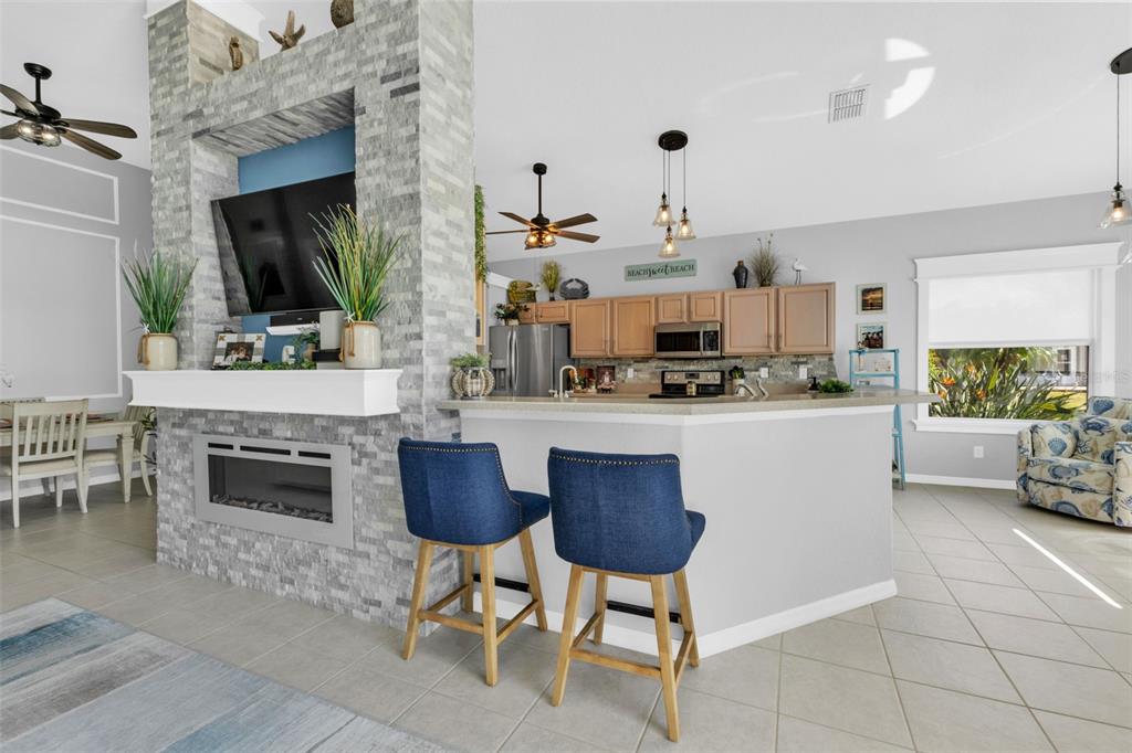 24439 Buckingham Way Punta Gorda, FL 33980 - Photo 10 of 42 a kitchen with stainless steel appliances kitchen island granite countertop a stove a sink and a microwave