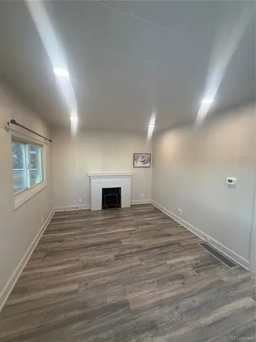 a view of empty room with wooden floor