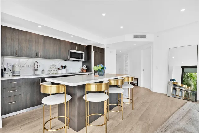 a kitchen with stainless steel appliances a stove a sink and a refrigerator