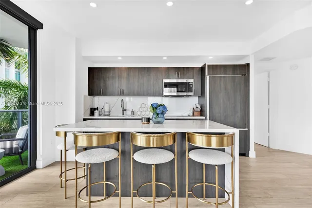 a kitchen with stainless steel appliances a dining table and chairs