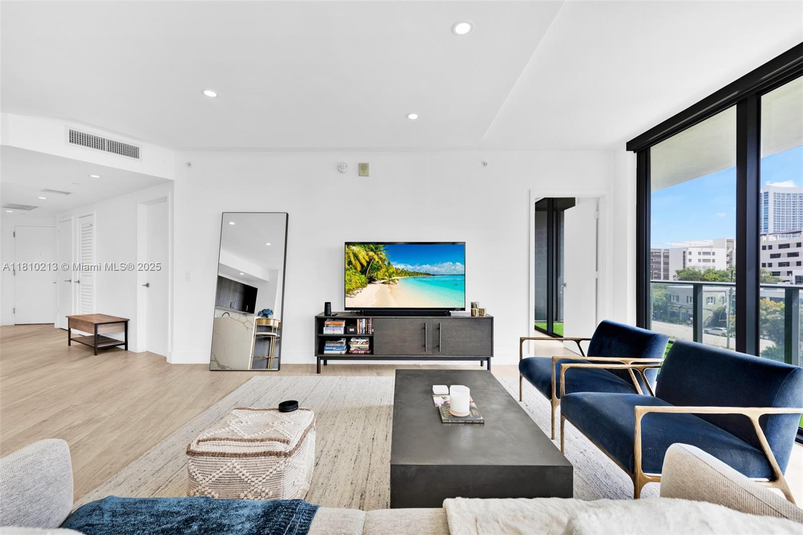 121 Northeast 34th Street, Unit L304 Miami, FL 33137 - Photo 2 of 36 a living room with furniture and a flat screen tv