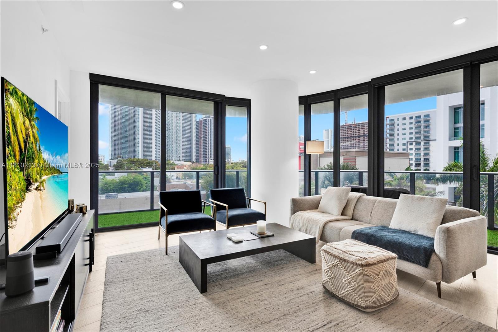 121 Northeast 34th Street, Unit L304 Miami, FL 33137 - Photo 3 of 36 a living room with fireplace furniture and a flat screen tv