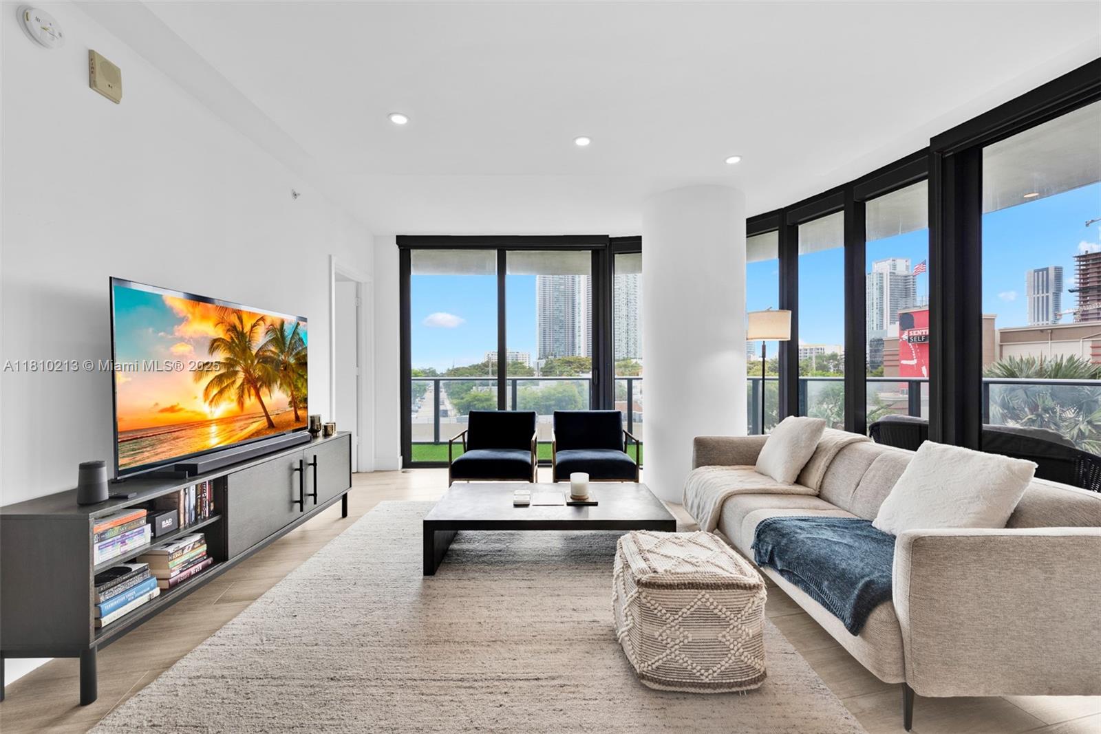 121 Northeast 34th Street, Unit L304 Miami, FL 33137 - Photo 4 of 36 a living room with furniture and a flat screen tv