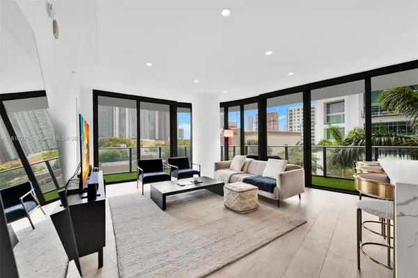 a living room with furniture floor to ceiling window and flat screen tv