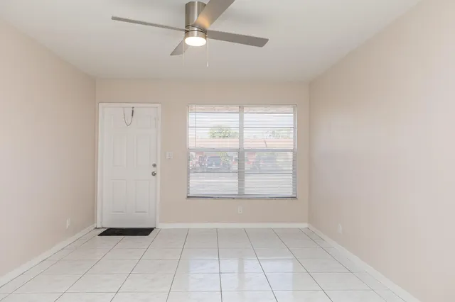 an empty room with windows and fan