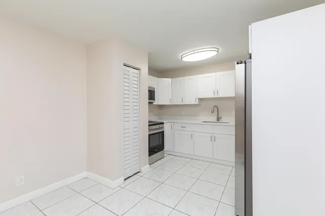 a kitchen with white cabinets and white appliances
