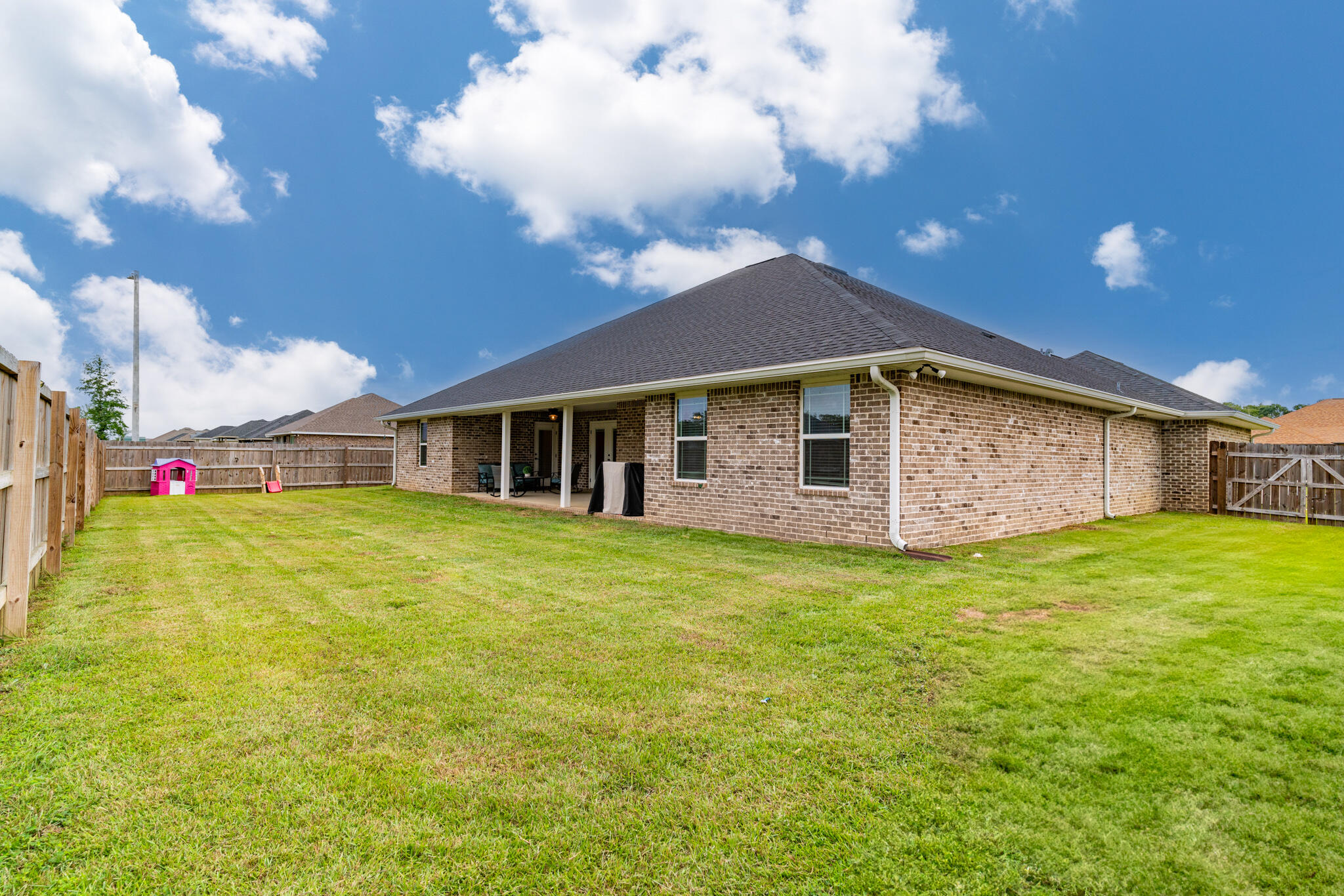 9180 Tara Circle Milton, FL 32583 - Photo 45 of 56 a yellow and red house with a garden