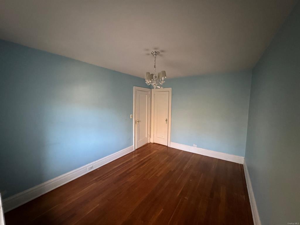 42 Pondfield Road, Unit 6C Bronxville, NY 10708 - Photo 18 of 21 Spare room with a chandelier and dark hardwood / wood-style flooring