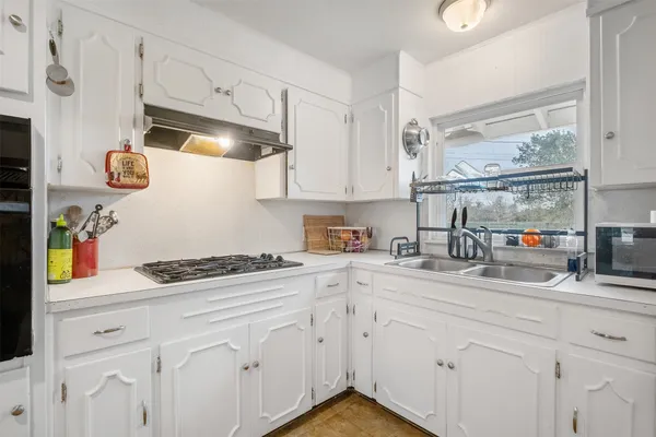 a kitchen with stainless steel appliances granite countertop a refrigerator a stove and a sink with wooden floor