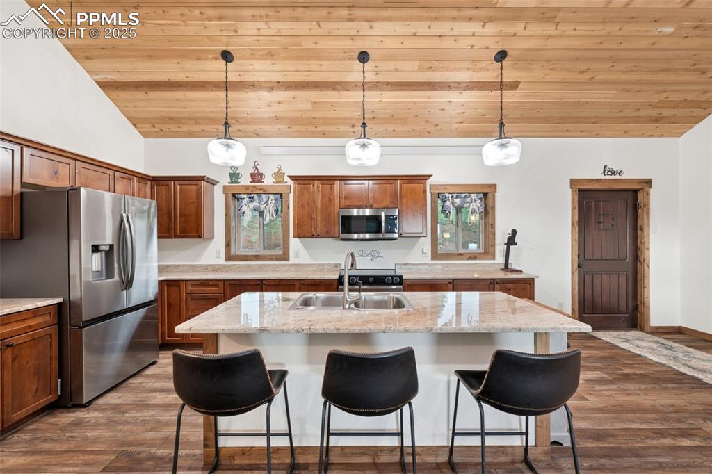 103 Copper Mountain Drive Cripple Creek, CO 80813 - Photo 11 of 29 a kitchen with stainless steel appliances kitchen island granite countertop a dining table chairs and a refrigerator