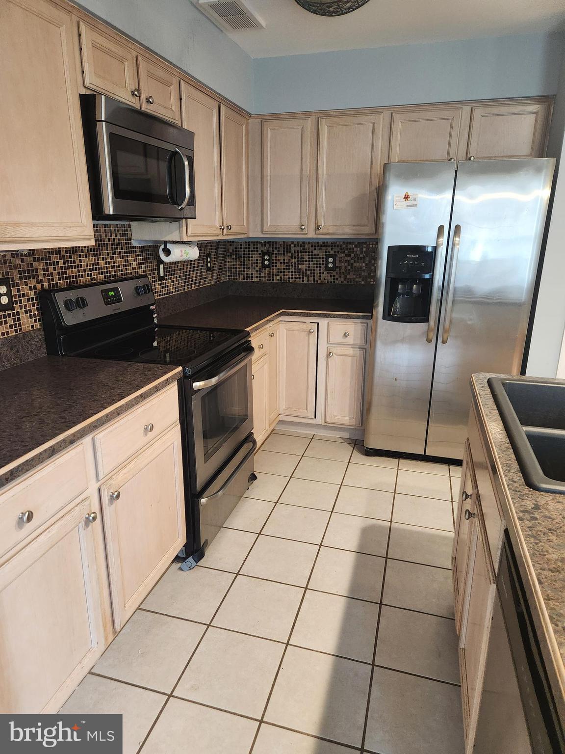 239 Morningside Drive Falling Waters, WV 25419 - Photo 3 of 20 a kitchen with granite countertop a stove a sink and a microwave