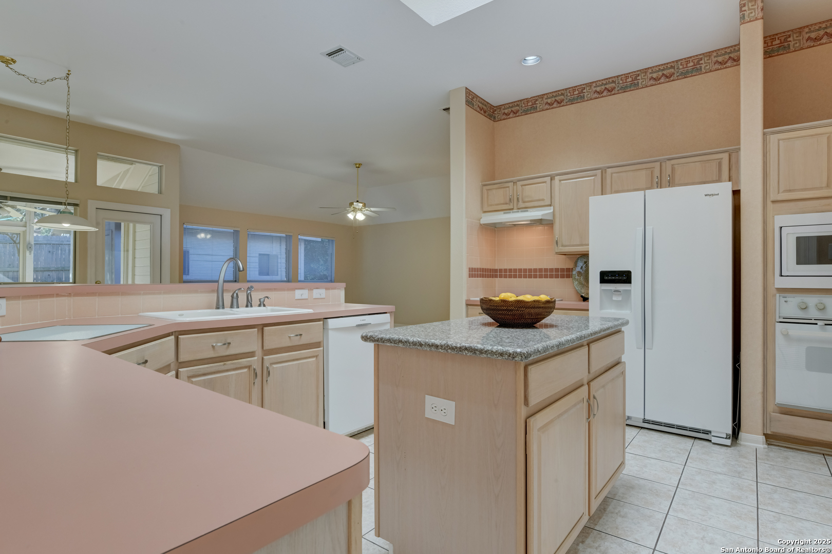 9923 Tezel Road San Antonio, TX 78254 - Photo 5 of 30 a kitchen with a sink a stove a refrigerator and white cabinets
