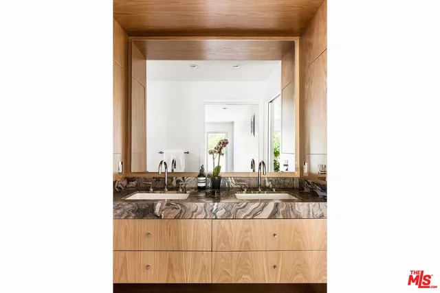 a bathroom with double vanity sinks a mirror and a shower