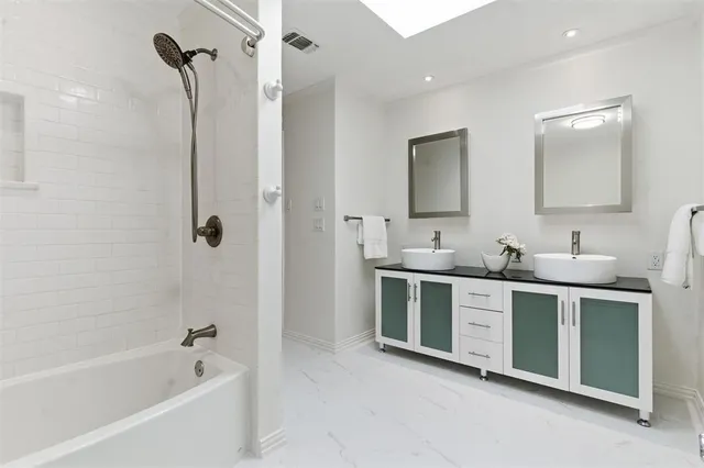 a bathroom with a tub sink and mirror