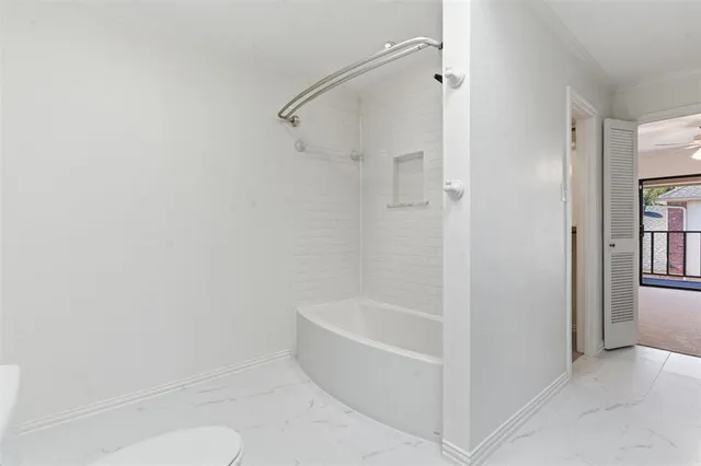a white bath tub sitting next to a white toilet
