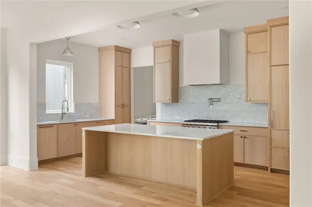 a kitchen with stainless steel appliances granite countertop a stove a sink and white cabinets