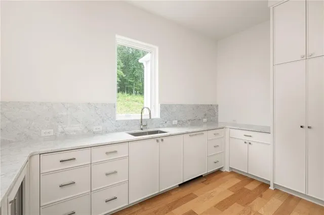 a bathroom with a granite countertop sink mirror and cabinets