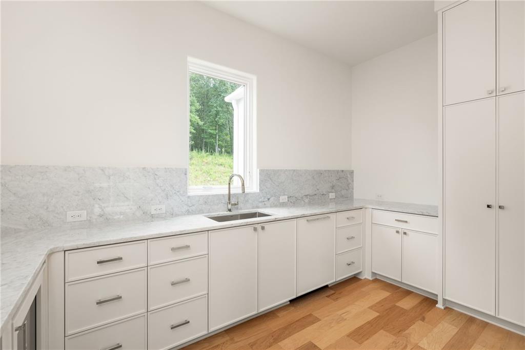 1064 Lupo Loop Chattahoochee Hills, GA 30268 - Photo 18 of 40 a bathroom with a granite countertop sink mirror and cabinets