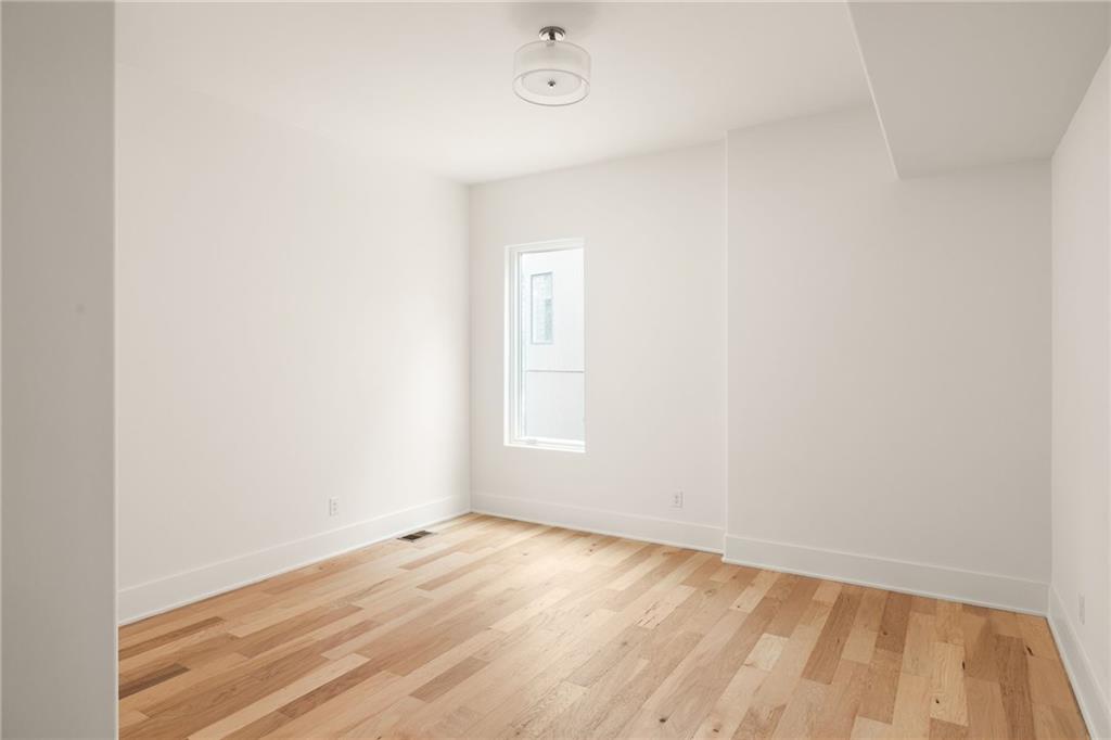 1064 Lupo Loop Chattahoochee Hills, GA 30268 - Photo 34 of 40 a view of an empty room with wooden floor and a window