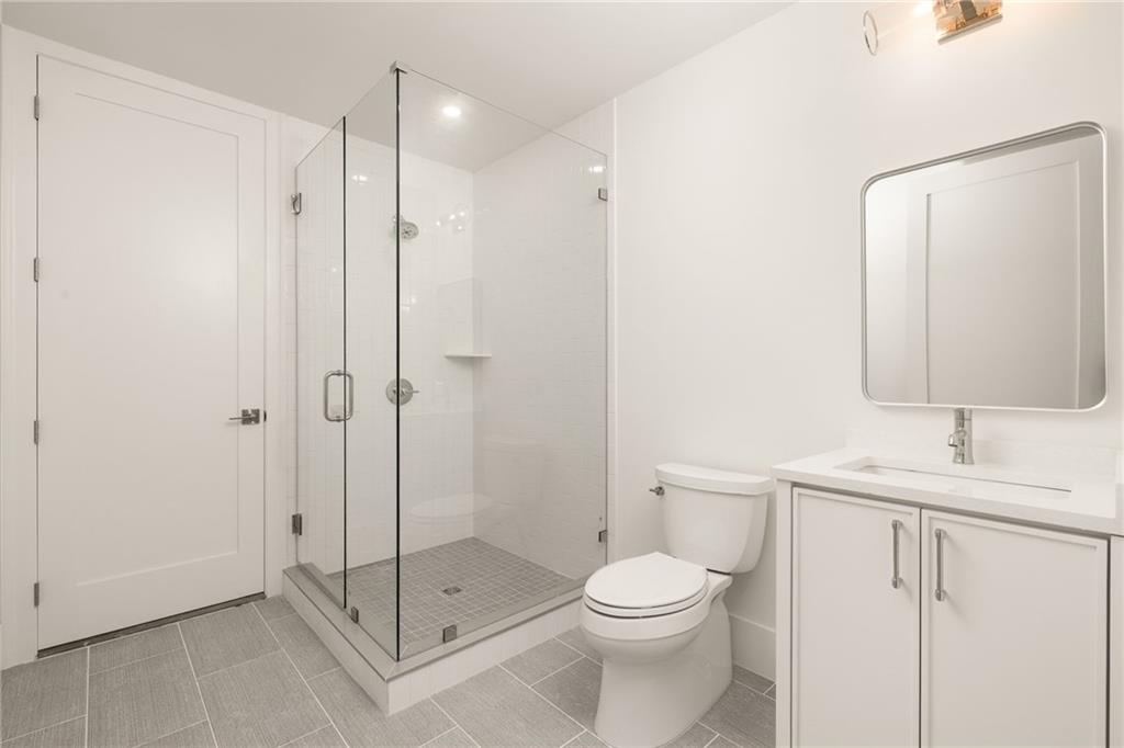 1064 Lupo Loop Chattahoochee Hills, GA 30268 - Photo 35 of 40 a bathroom with a toilet a sink and a shower