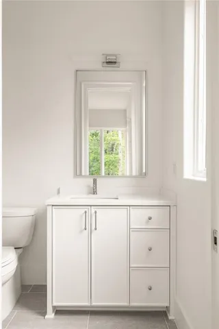 a bathroom with a sink a toilet and a window