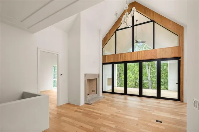 a view of an empty room with wooden floor and windows
