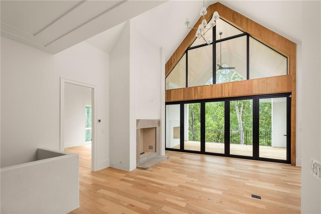 1064 Lupo Loop Chattahoochee Hills, GA 30268 - Photo 7 of 40 a view of an empty room with wooden floor and windows