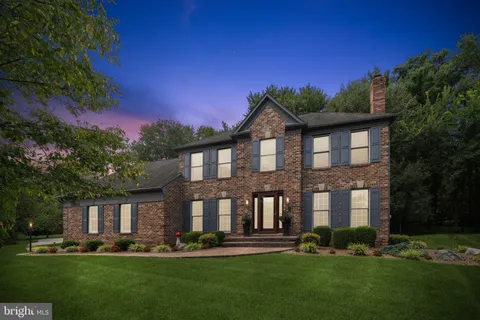a front view of a house with a yard and trees