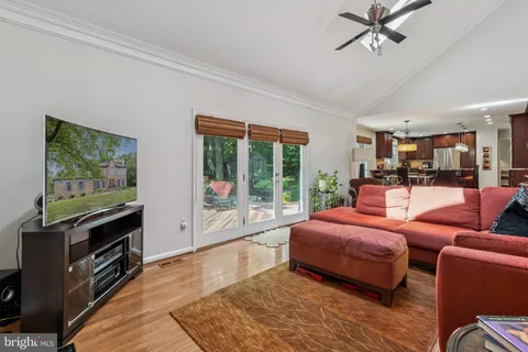 a living room with furniture a flat screen tv and a floor to ceiling window