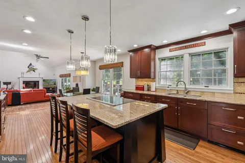 a open kitchen with stainless steel appliances granite countertop a sink a stove and a wooden floors