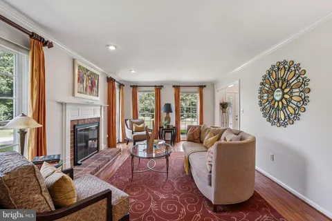 a living room with fireplace furniture and a large window