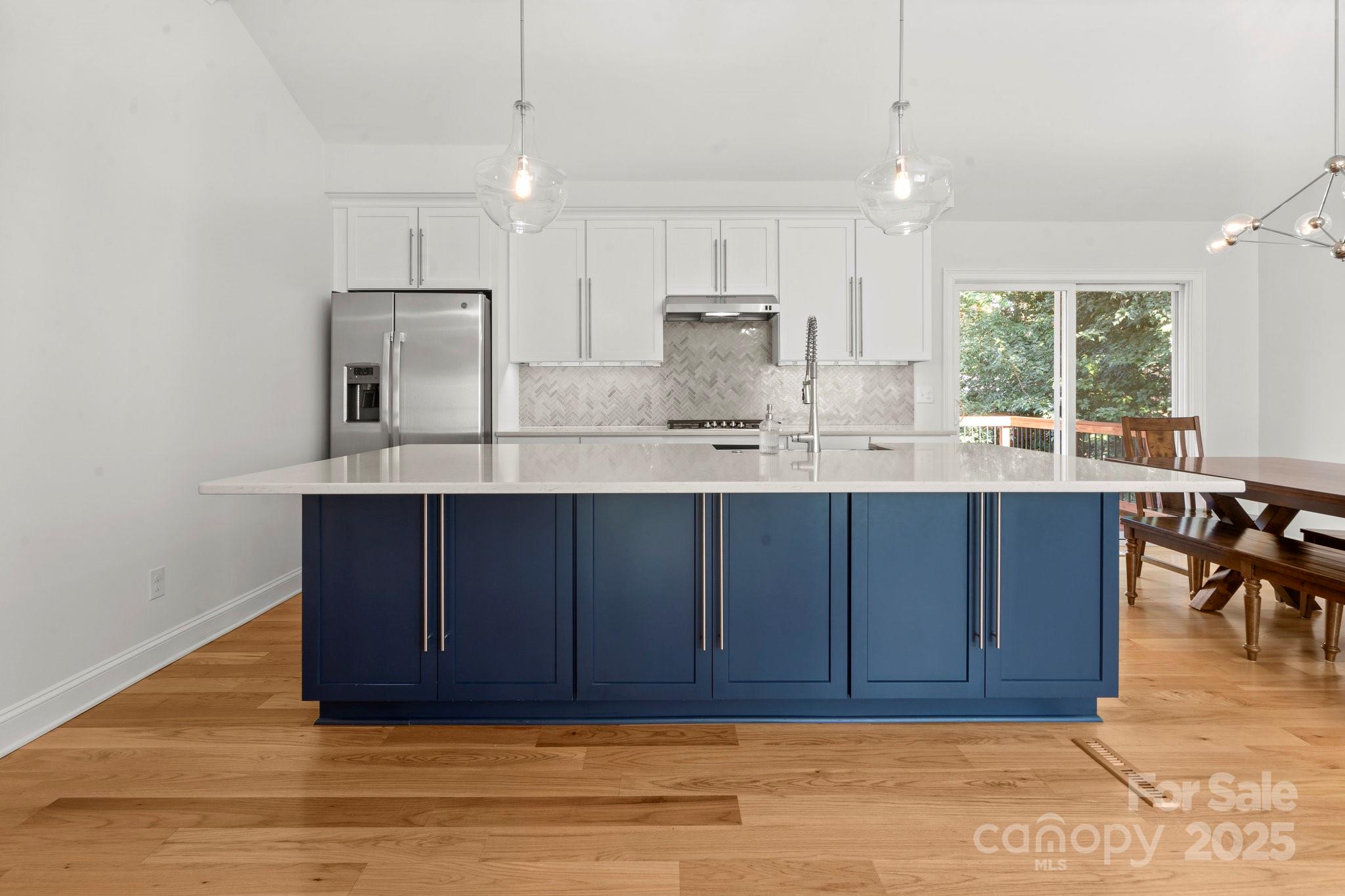 4816 Fairheath Road Charlotte, NC 28210 - Photo 11 of 35 a kitchen with kitchen island granite countertop a sink cabinets and wooden floor