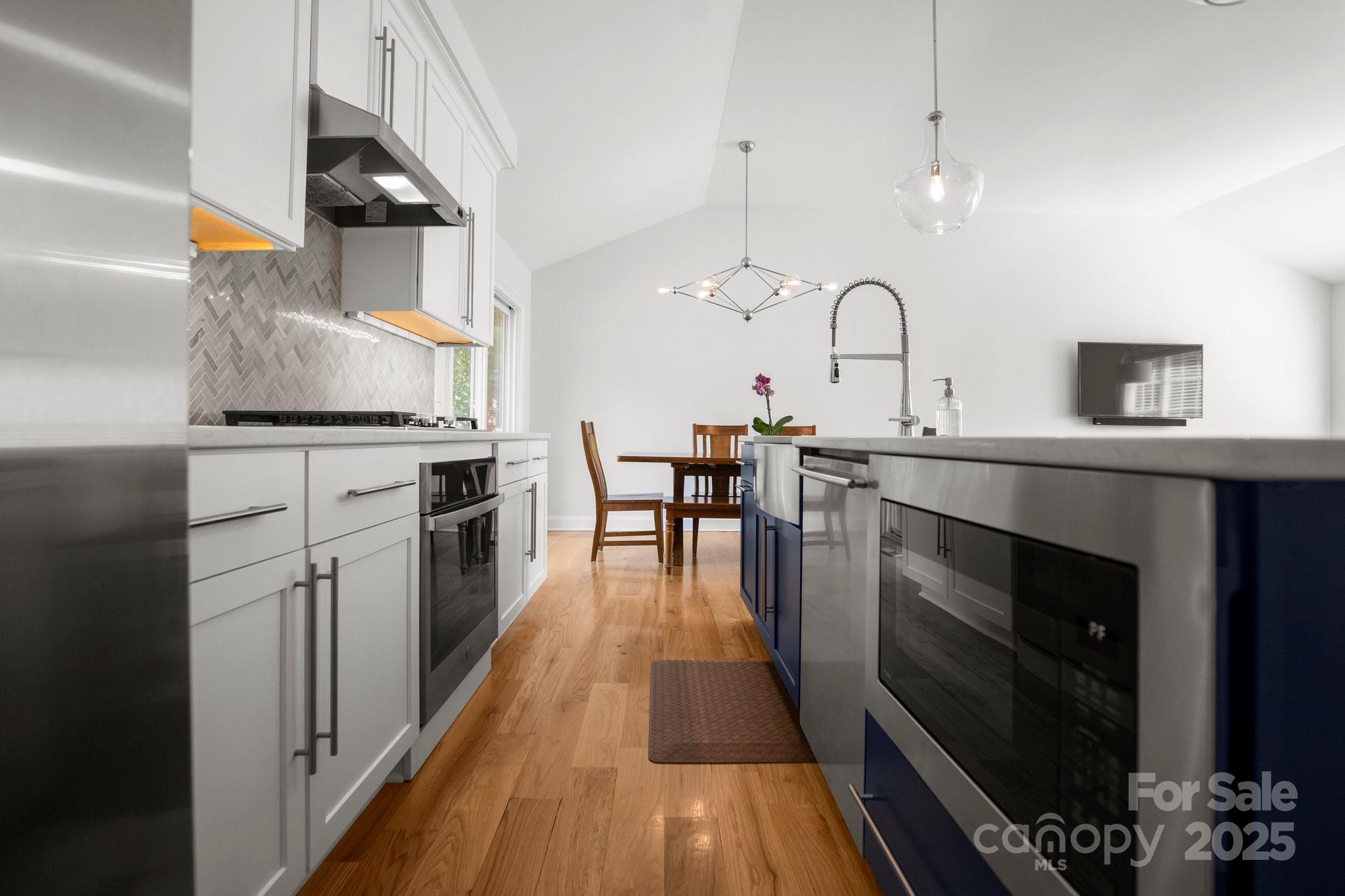 4816 Fairheath Road Charlotte, NC 28210 - Photo 12 of 35 a kitchen with stainless steel appliances granite countertop a stove a sink and a wooden floors