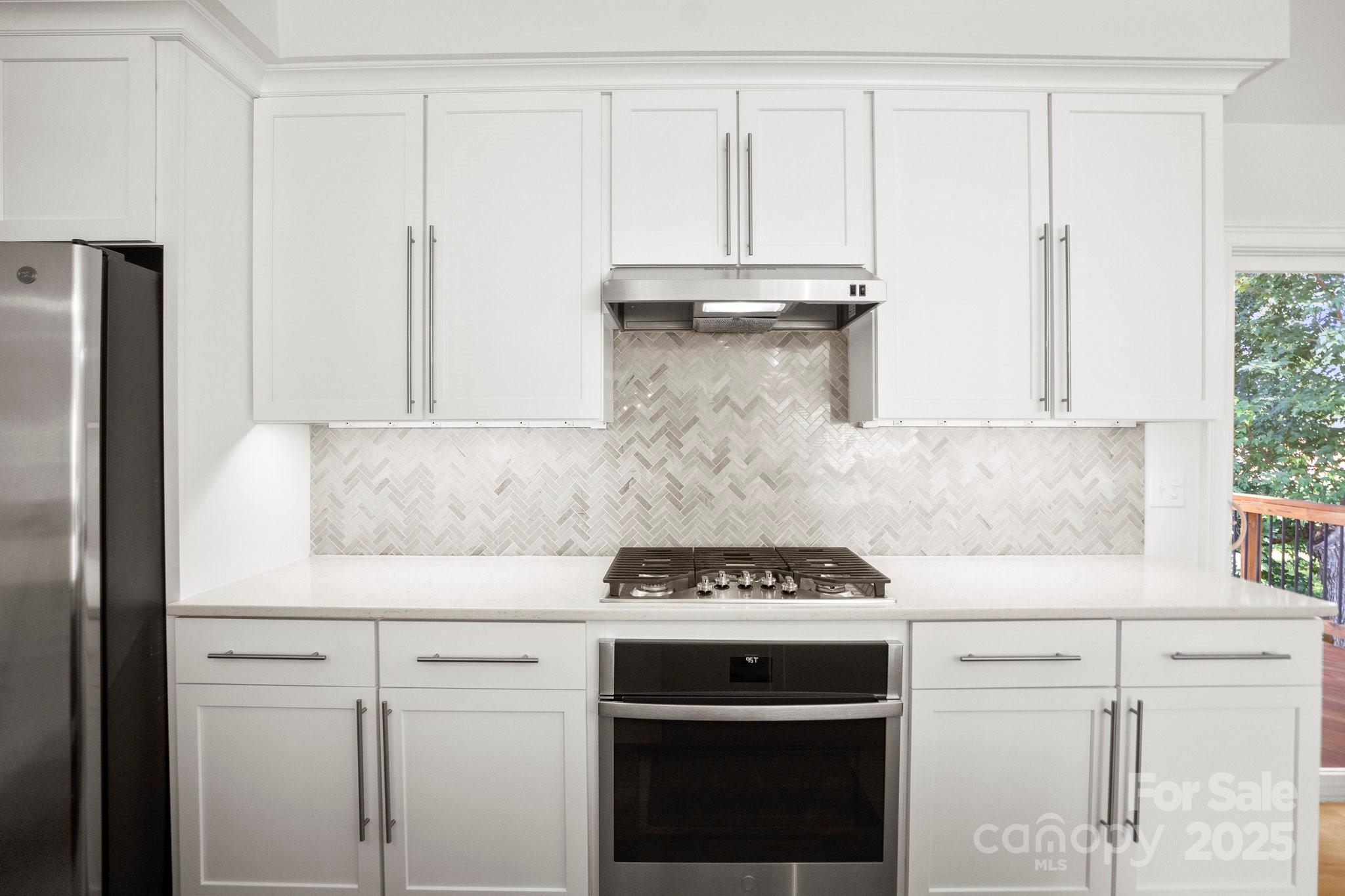 4816 Fairheath Road Charlotte, NC 28210 - Photo 13 of 35 a kitchen with white cabinets and a stove