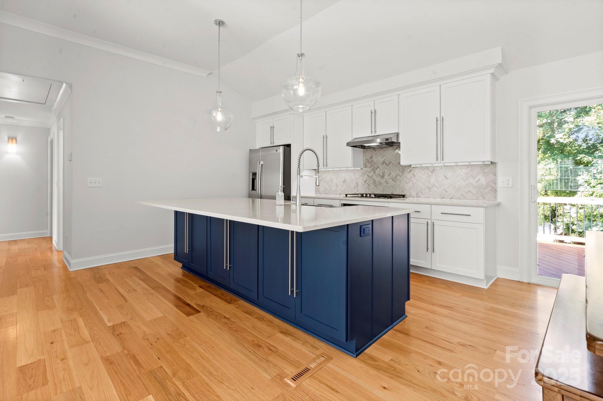 4816 Fairheath Road Charlotte, NC 28210 - Photo 14 of 35 a kitchen with kitchen island a sink stainless steel appliances and cabinets