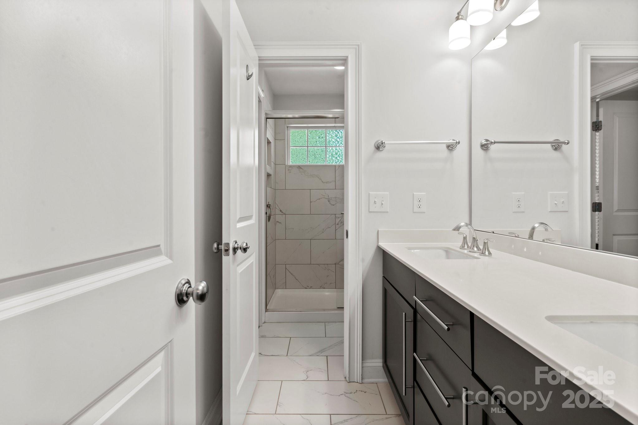 4816 Fairheath Road Charlotte, NC 28210 - Photo 26 of 35 a bathroom with a double vanity sink mirror and shower