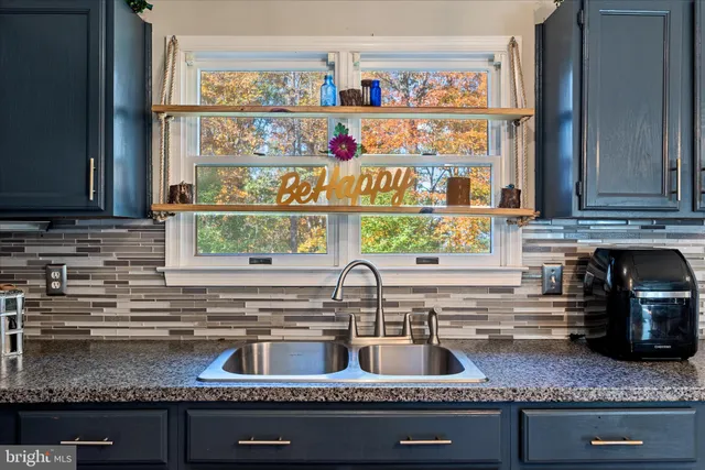 a kitchen with granite countertop a sink and a stove