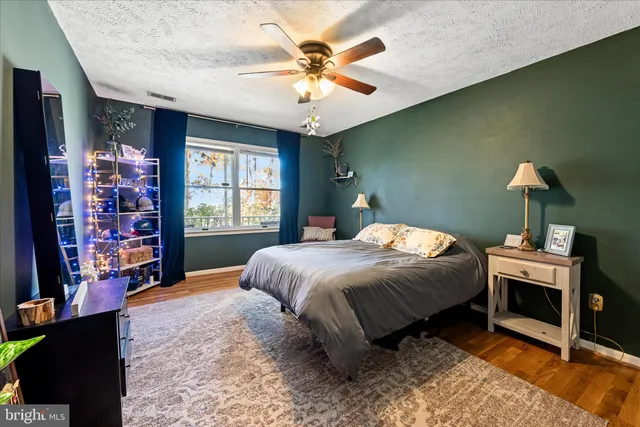 a bedroom with a bed bookshelf and a large window