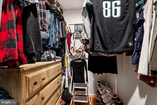 a view of walk in closet with clothes and shoes