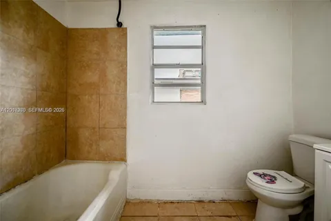a white toilet sitting next to a shower