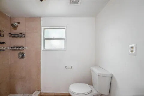 a bathroom with a granite countertop sink a toilet and a shower