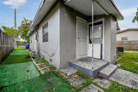 a view of backyard of house with wooden fence