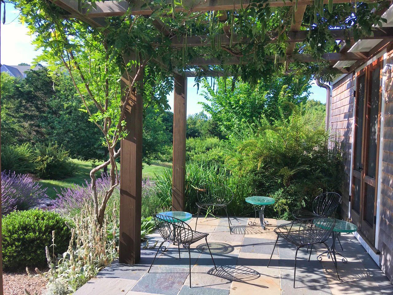 53 Depot Road Truro, MA 02666 - Photo 15 of 29 a view of a patio with table and chairs potted plants and large tree