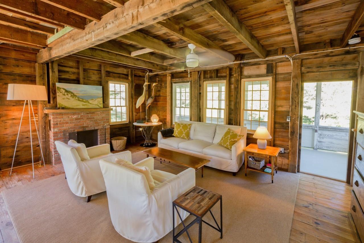 53 Depot Road Truro, MA 02666 - Photo 24 of 29 a living room with furniture and a fireplace