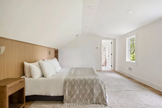 a spacious bedroom with a bed and a window